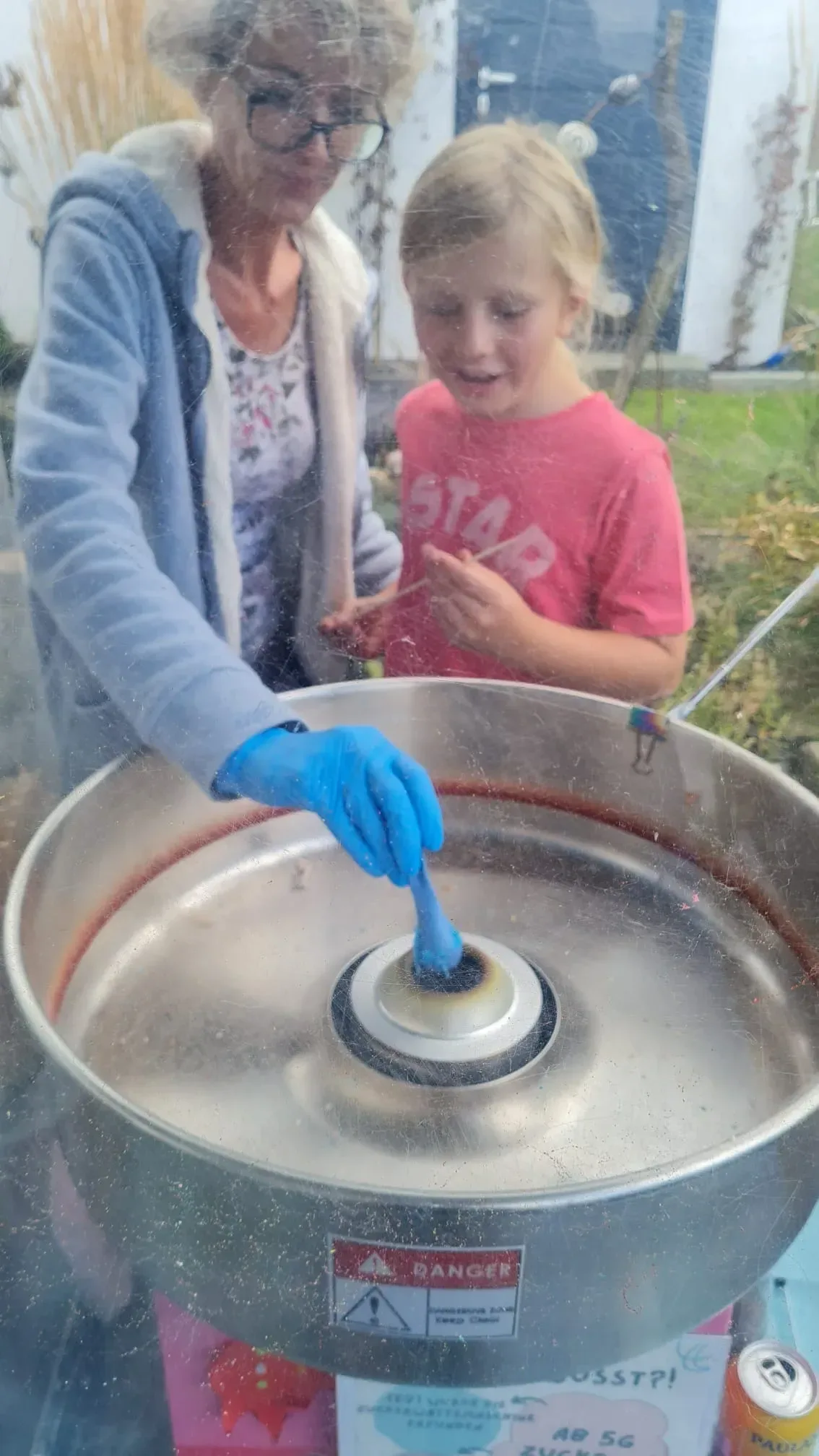 Kind dreht mit Unterstützung zum ersten Mal eigene Zuckerwatte