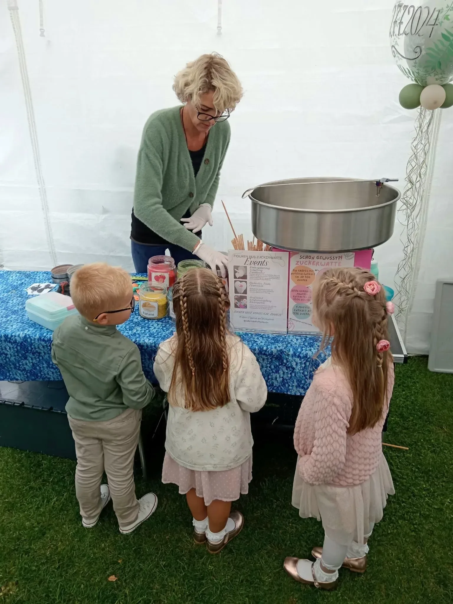 Kinder warten gespannt an der Maschine auf ihre Wunsch-Zuckerwatte